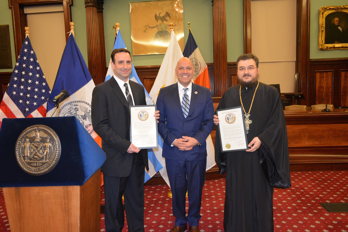 Councilman Paul Vallone, center, stands with George Isaakidis, left, and Rev. Fr. Dionysios Anognostopoulos, right, at City Hall.